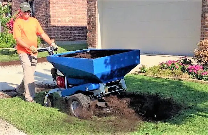 A person using a machine to grind the ground.