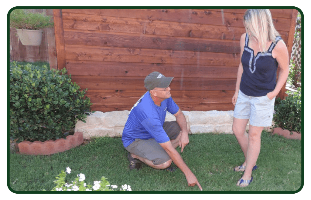 A man kneeling down in the grass next to a woman.